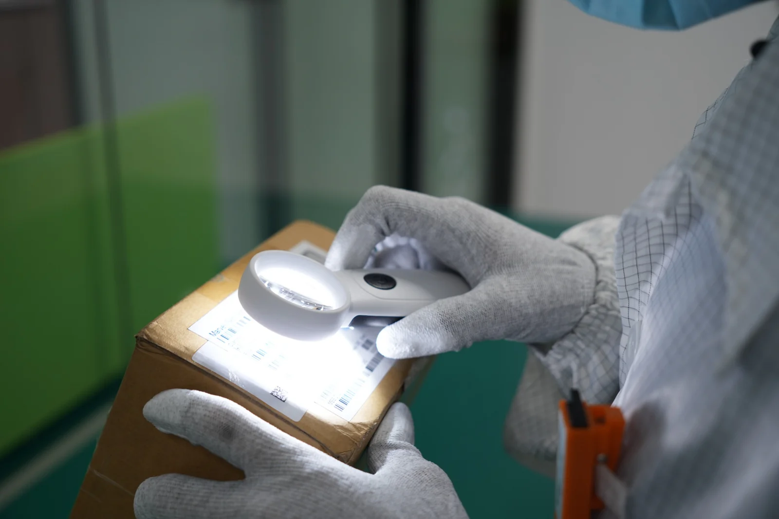 Quality inspector examining a component package label under magnification