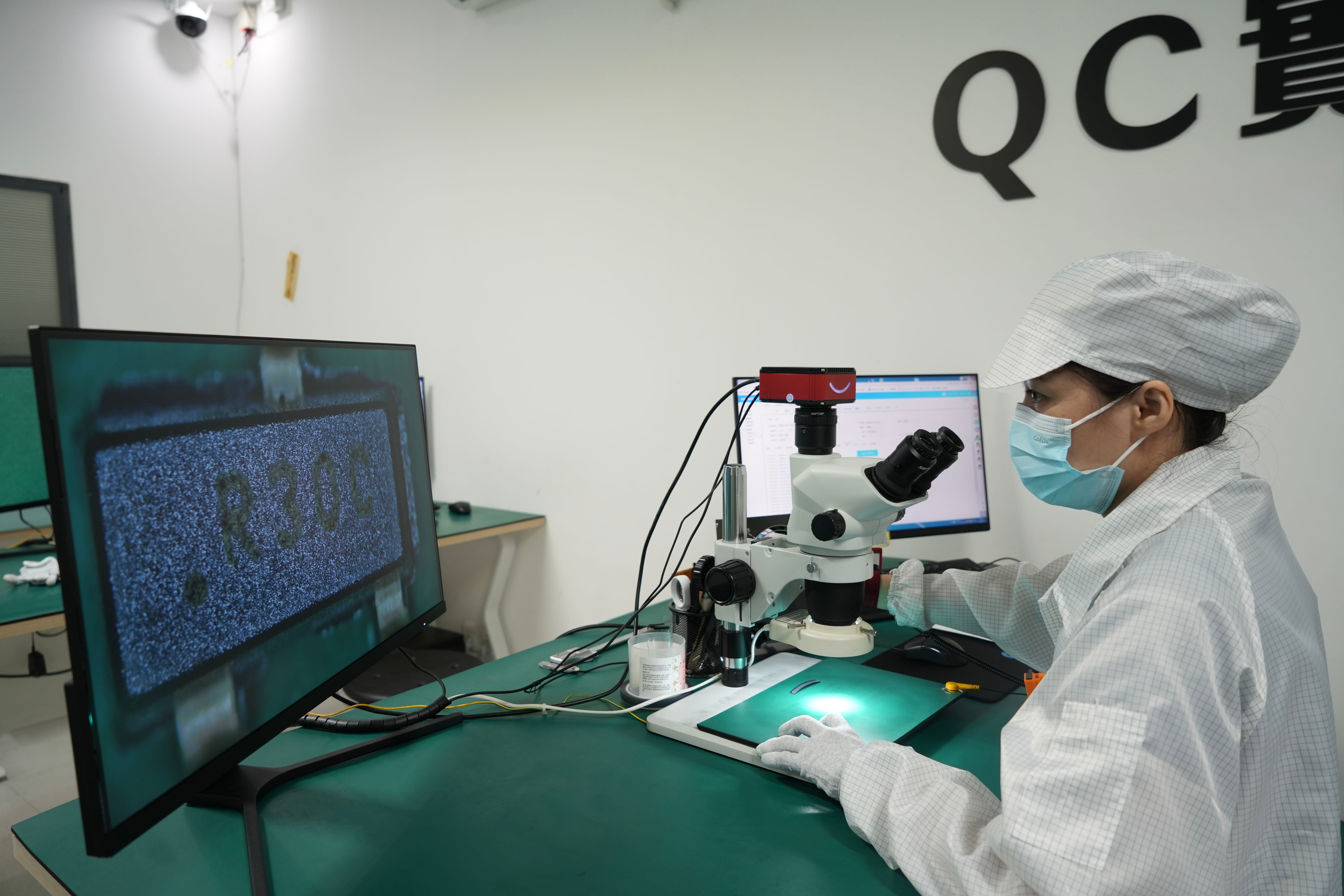 Technician performing detailed visual inspection with a laboratory microscope