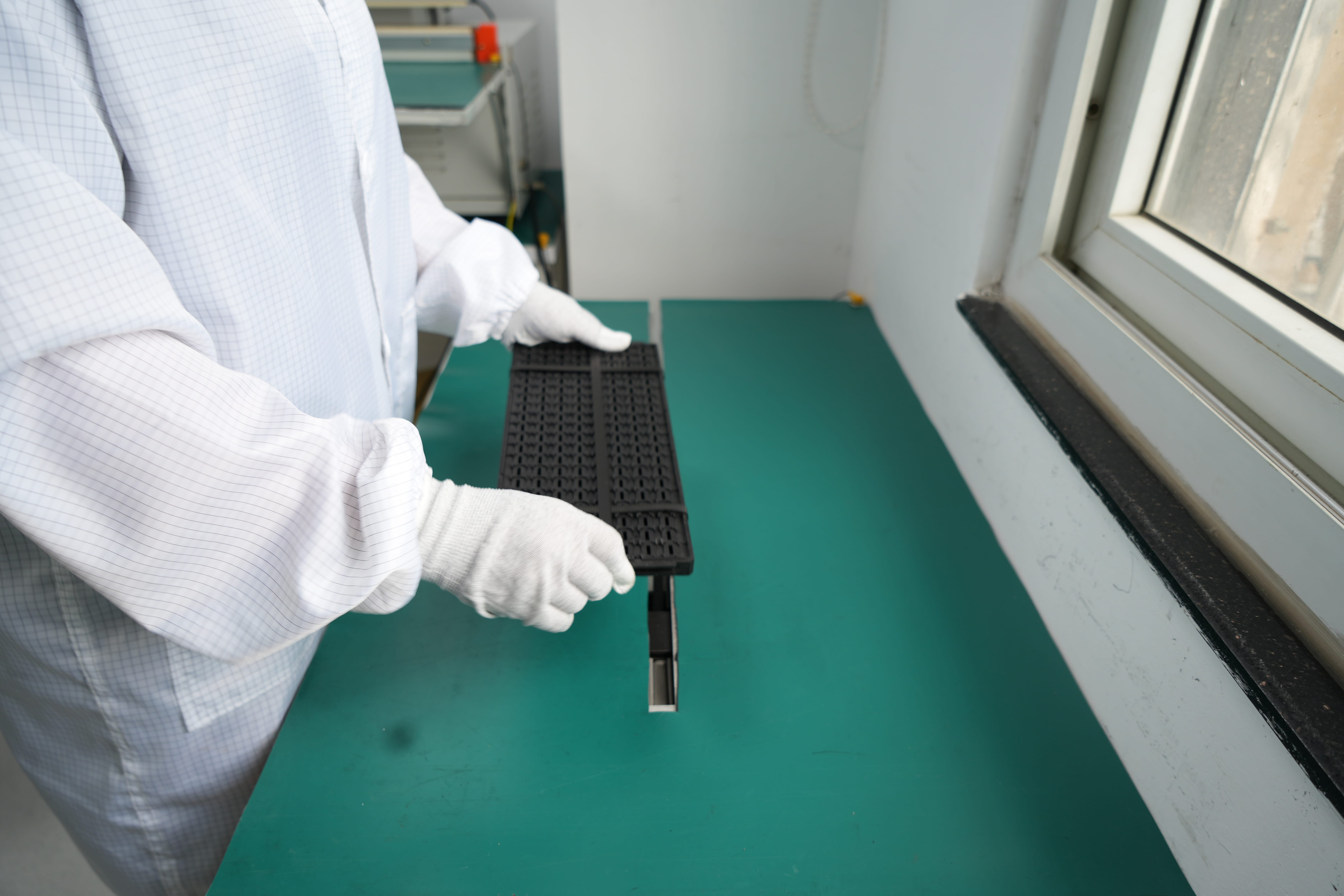 Laboratory technician measuring electronic component packaging with precision equipment