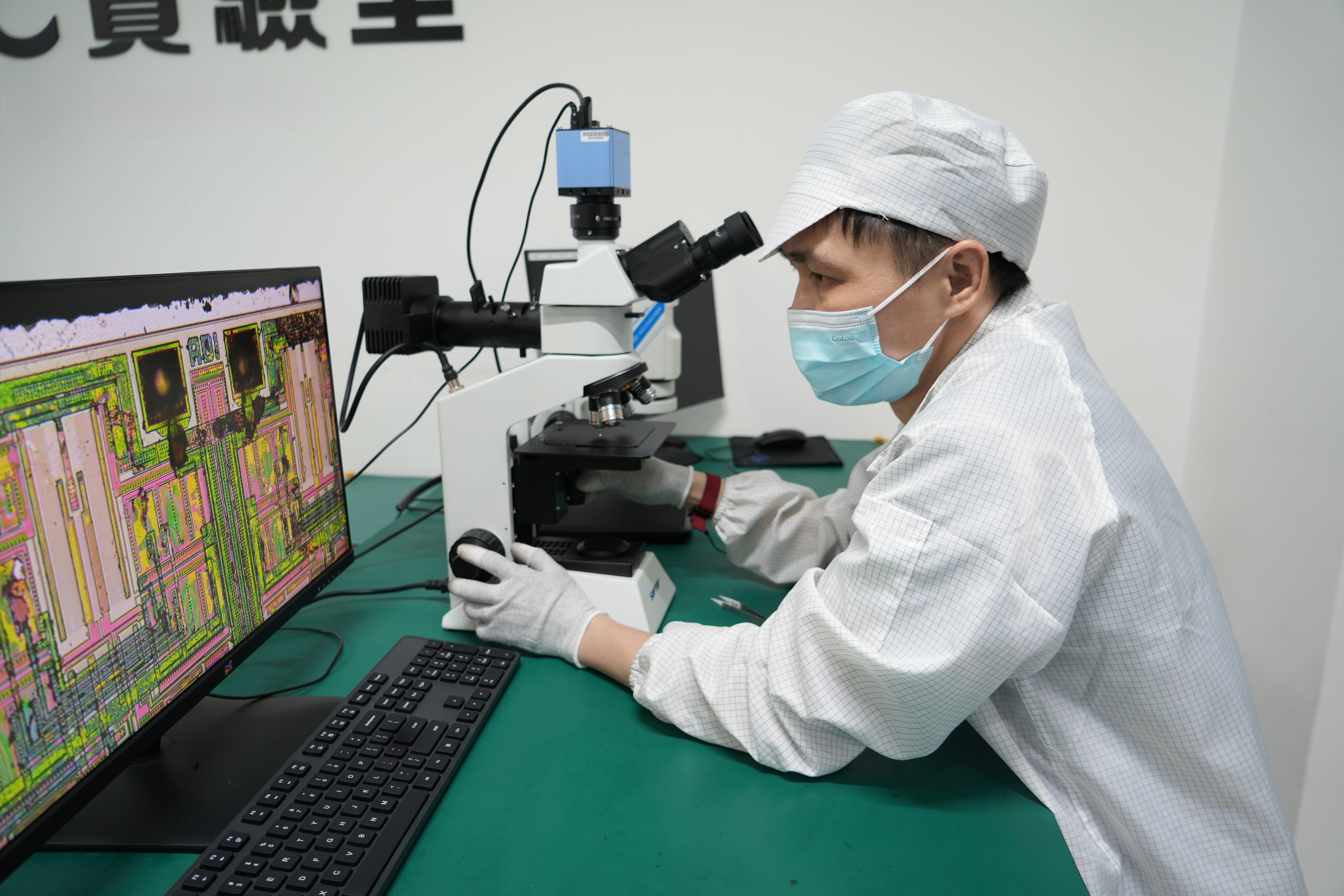 Quality technician examining a semiconductor die under a laboratory microscope